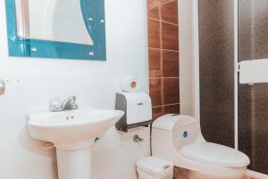 a white bathroom with a toilet and a sink at APARTAHOTEL BEIRUT INN in San Andrés