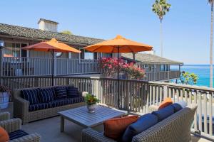 une terrasse avec des canapés et une table avec un parasol dans l'établissement Scripps Inn, à San Diego