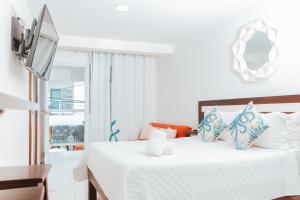 Un dormitorio con una cama blanca con almohadas azules y blancas en APARTAHOTEL BEIRUT INN en San Andrés