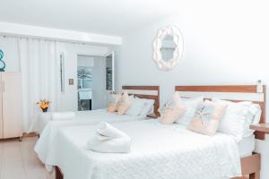 two beds in a room with white and pink pillows at APARTAHOTEL BEIRUT INN in San Andrés