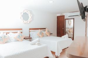 a bedroom with two beds and a mirror at APARTAHOTEL BEIRUT INN in San Andrés