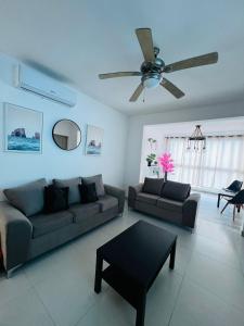 ein Wohnzimmer mit einem Sofa und einem Deckenventilator in der Unterkunft La rose in Punta Cana