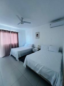 ein Hotelzimmer mit 2 Betten und einem Deckenventilator in der Unterkunft La rose in Punta Cana