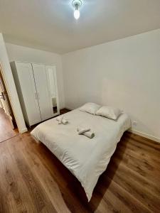 um quarto com uma cama com dois chinelos em Superbe appartement Paris/Bagnolet 203 em Bagnolet