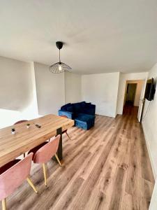 ein Wohnzimmer mit einem Holztisch und einem blauen Sofa in der Unterkunft Superbe appartement Paris/Bagnolet 203 in Bagnolet