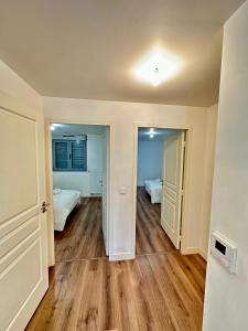 an empty room with two beds and wooden floors at Superbe appartement Paris/Bagnolet 203 in Bagnolet
