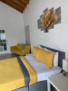 a bedroom with a bed and a yellow chair at Large Modern Space in Cedar Grove