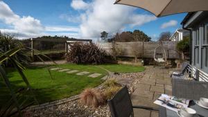 a patio with an umbrella and a garden at Number Nine in Lanchester