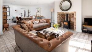 a living room with a leather couch and a fireplace at Number Nine in Lanchester