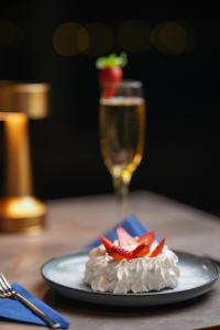 einen Teller mit Erdbeeren auf dem Tisch mit einem Glas Wein in der Unterkunft Majesty Bosphorus in Istanbul