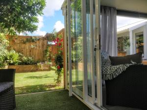 a screened in porch with a view of a yard at Tranquil Garden Studio in Tauranga