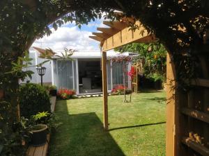 a pergola in the backyard of a house at Tranquil Garden Studio in Tauranga