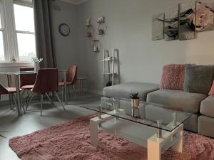 uma sala de estar com um sofá e uma mesa em Stunning 2 Bedroom Flat Next to Victoria Hospital em Fife