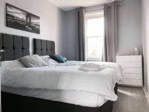 een slaapkamer met een groot bed en een raam bij Stunning 2 Bedroom Flat Next to Victoria Hospital in Fife