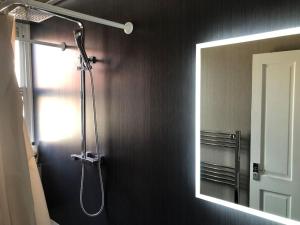 a shower in a bathroom with a mirror at Stunning 2 Bedroom Flat Next to Victoria Hospital in Fife +10 photos