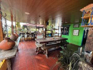 um restaurante com mesas de madeira e paredes verdes em Finca La Española Quimbaya Quindio em Quimbaya
