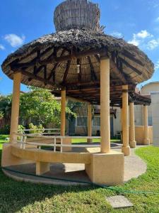 a pavilion with a bench under a large umbrella at Casa para 8 personas in Zihuatanejo