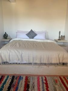 een slaapkamer met een groot bed en 2 tafels bij Momo's beach house in Aghnajane