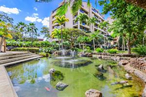 a fountain in a pond in front of a building at Sands of Kahana Vacation Club in Lahaina