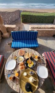 uma mesa com comida para o pequeno almoço ao lado da praia em Momo's beach house em Aghnajane