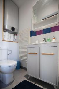 ein weißes Bad mit einem WC und einem Waschbecken in der Unterkunft 2 pièces Cosy - proche RER A - proche Paris in Houilles