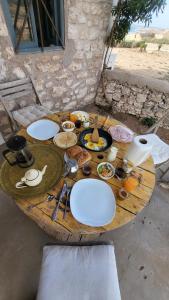 a wooden table with plates of food on it at Momo's beach house in Aghnajane