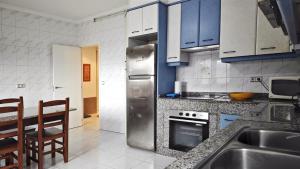 a kitchen with a stainless steel refrigerator and a table at Casa Fenteira in Poio