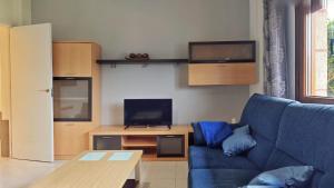 a living room with a blue couch and a tv at Casa Fenteira in Poio