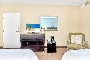 um quarto de hotel com uma cama e uma cadeira em Apt Close to Universal Studios with Hot tub Pool em Orlando