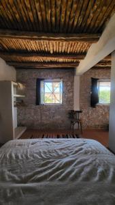 1 dormitorio con 1 cama grande y 2 ventanas en Momo's beach house en Aghnajane