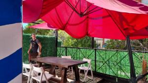 a man standing next to a table with two large umbrellas at Loft casa dos pisos con garage pocitos playa 4 personas in Montevideo