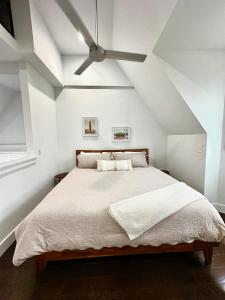 a bedroom with a bed with a ceiling fan at CWE Luxury La Maison Modern in Tower Grove