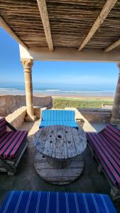 einen Tisch und Stühle auf einer Veranda mit Meerblick in der Unterkunft Momo's beach house in Aghnajane