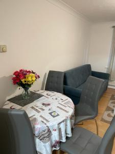 a room with a table with a vase of flowers on it at Charming Escape: 2BR Home with Parking in Aveley