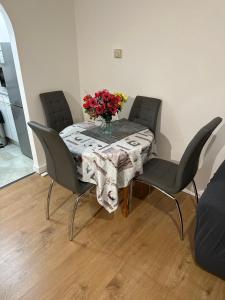 uma mesa com cadeiras e um vaso de flores sobre ela em Charming Escape: 2BR Home with Parking em Aveley