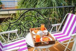 una mesa con una bandeja de comida y zumo de naranja en Sky Garden Sarandi [ SuperLoft ] Pool & Barbacue, en Montevideo
