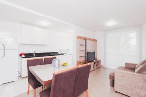 uma cozinha e sala de jantar com mesa e cadeiras em Apartamento Aconchegante Maia 404 em Caxias do Sul