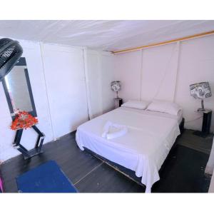 a bedroom with a white bed in a tent at Hostal la Canoa in Playa Blanca