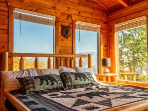 a bedroom with a bed in a log cabin at Grand Mountain View Lodge By Ghosal Luxury Lodging in Sevierville