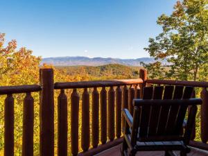 a bench sitting on a balcony with a view at Grand Mountain View Lodge By Ghosal Luxury Lodging in Sevierville