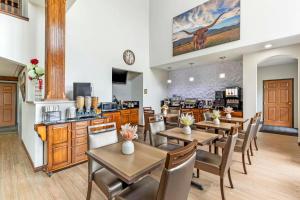 a restaurant with tables and chairs and a kitchen at Best Western Fort Worth Inn and Suites in Fort Worth