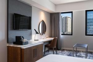 a hotel room with a desk and a mirror at Radisson Hotel Cape Town Foreshore in Cape Town
