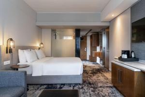 um quarto de hotel com uma cama e um sofá em Radisson Hotel Cape Town Foreshore na Cidade do Cabo