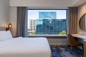 una stanza d'albergo con un letto, una scrivania e una finestra di Radisson Hotel Cape Town Foreshore a Città del Capo Altre 112 foto
