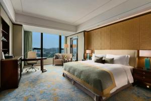 Cette chambre comprend un grand lit et un bureau. dans l'établissement Kempinski Hotel Xiamen, à Xiamen