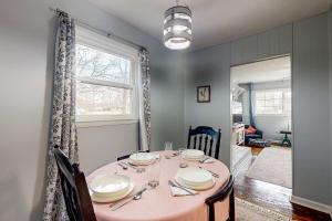 een eetkamer met een roze tafel en een raam bij Half Moon Cottage in Jacksonville