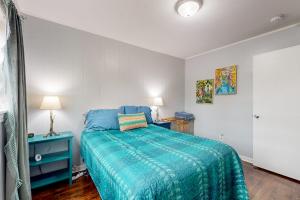 a bedroom with a bed with a blue comforter at Half Moon Cottage in Jacksonville