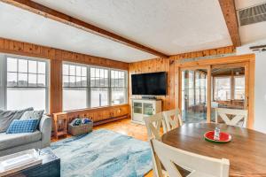 uma sala de estar com uma mesa e um sofá em Classic Waterfront Home on Lake Maspenock with Grill em Hopkinton