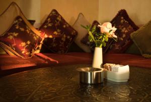 uma sala de estar com uma mesa com um vaso de flores em Djibouti Palace Kempinski em Djibouti