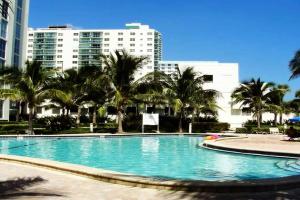 a large swimming pool with palm trees and buildings at PROMO Komffy Apt with 2 Queen Beds & Ocean View at Tides 7th floor in Hollywood